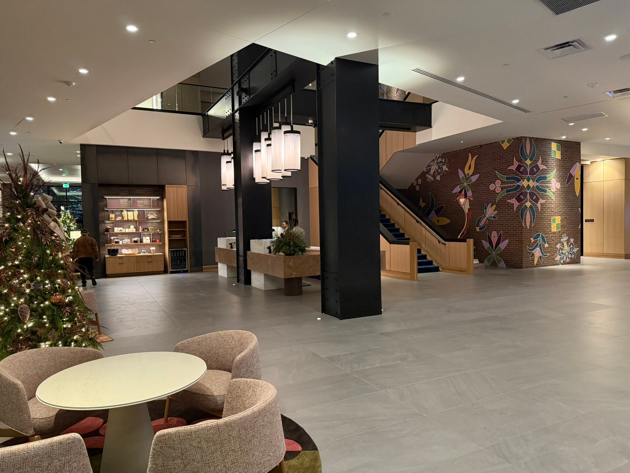 Hotel lobby marketplace and coffee bar with pendant lighting and lounge seating