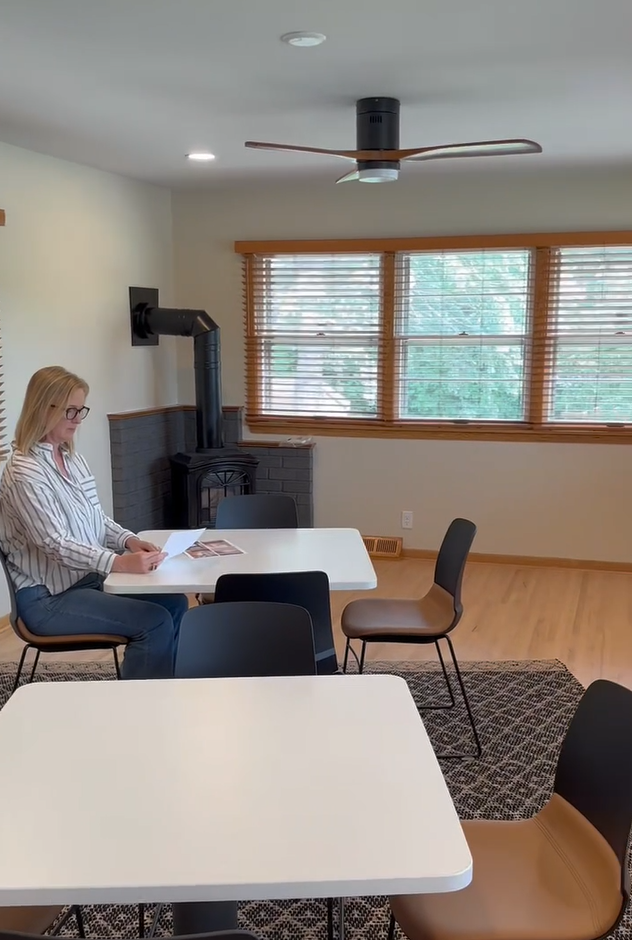Covington lounge seating area with wood stove fireplace and ceiling fan