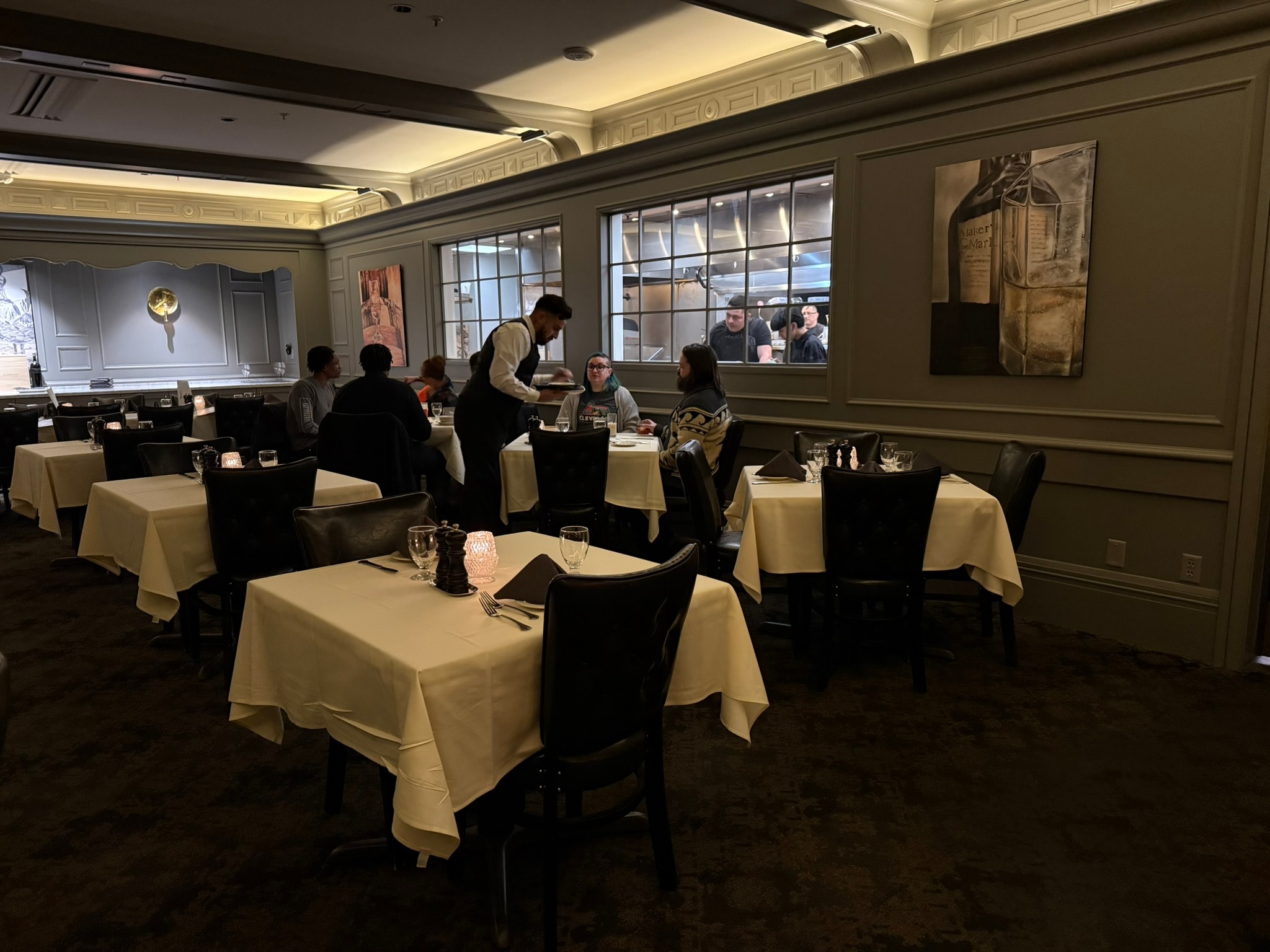 The Lexington second dining room with sage paneling and open kitchen view