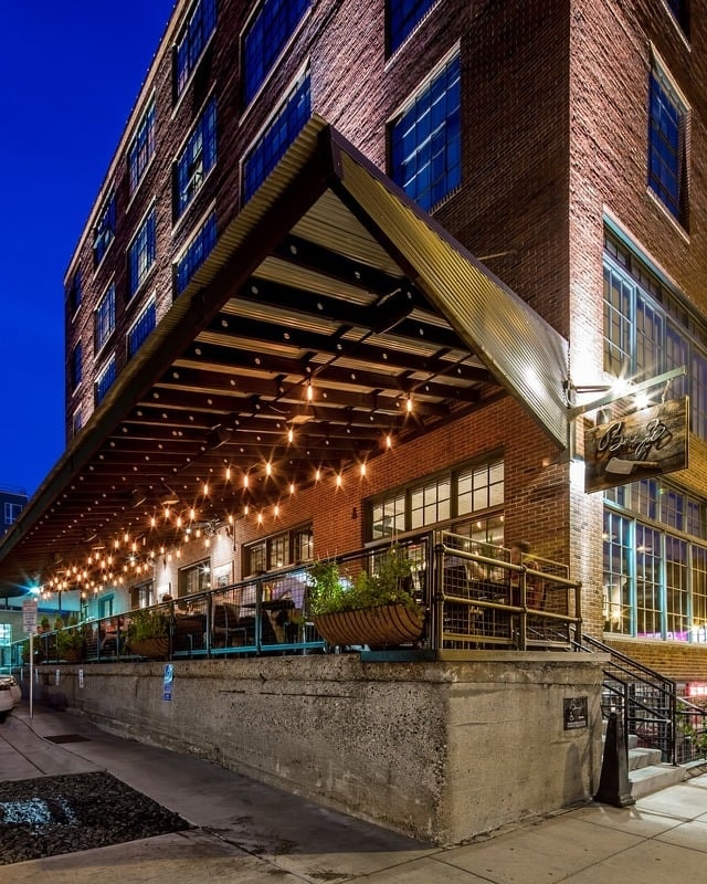 Borough - exterior at dusk with illuminated awning, string lights, and brick facade