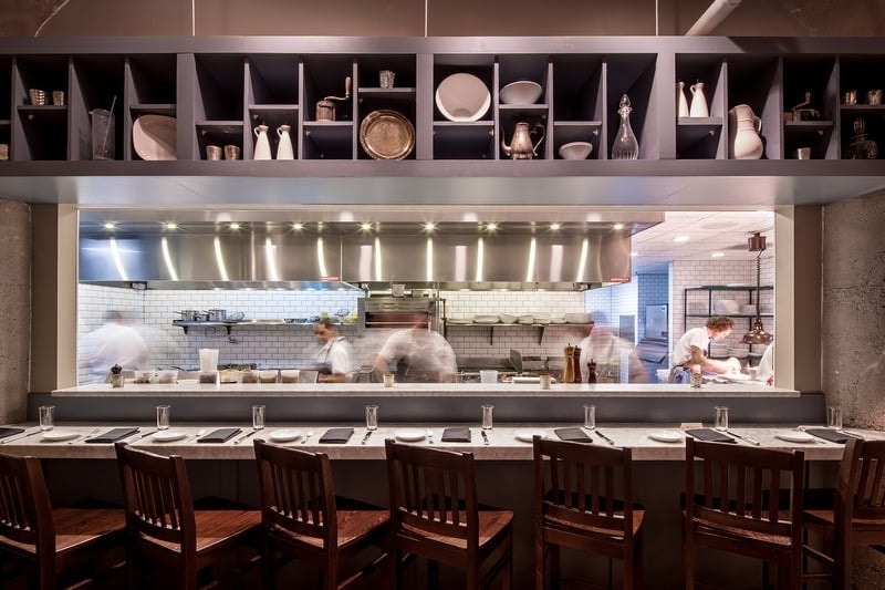 Borough - open kitchen counter with chefs at work and display shelving above