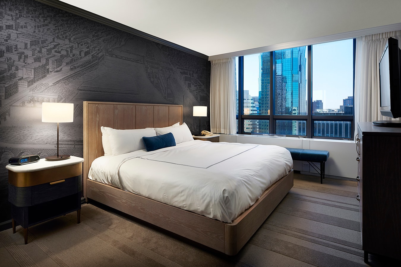 Marquette Hotel - guest room with city view, map wallpaper, and wood headboard