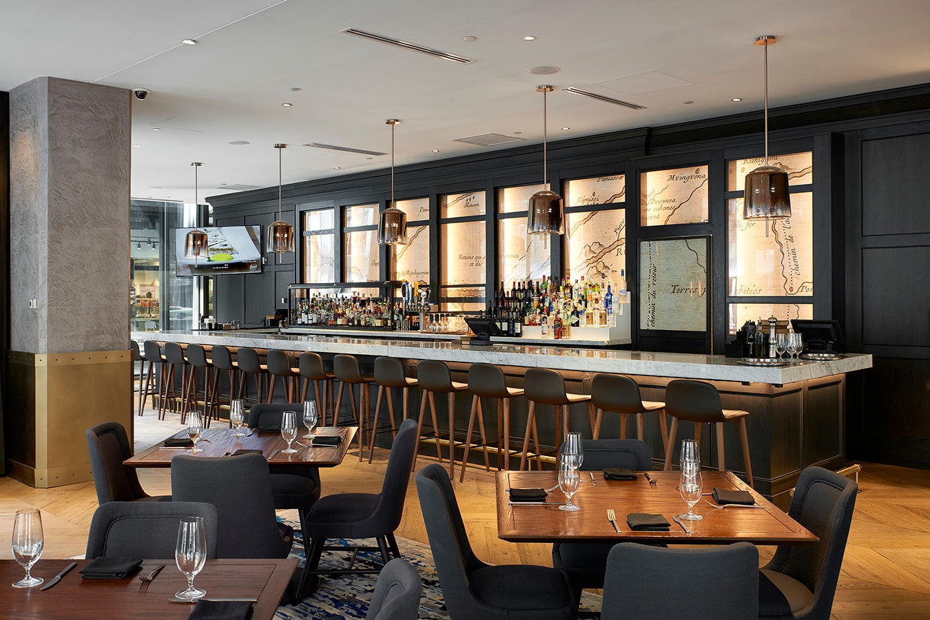 Marquette Hotel - bar with dark paneling, map art, and marble counter