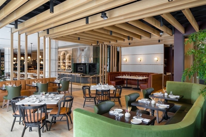 Rosewild - open dining floor with mixed seating, wood ceiling, and bar beyond