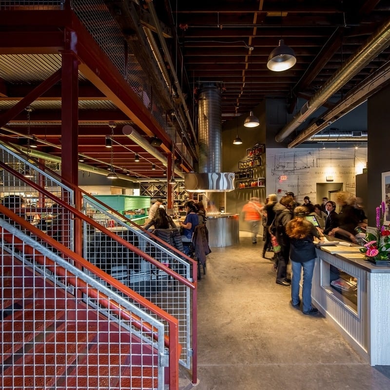 Smack Shack MPLS - circular stainless steel bar with green accent wall and industrial staircase
