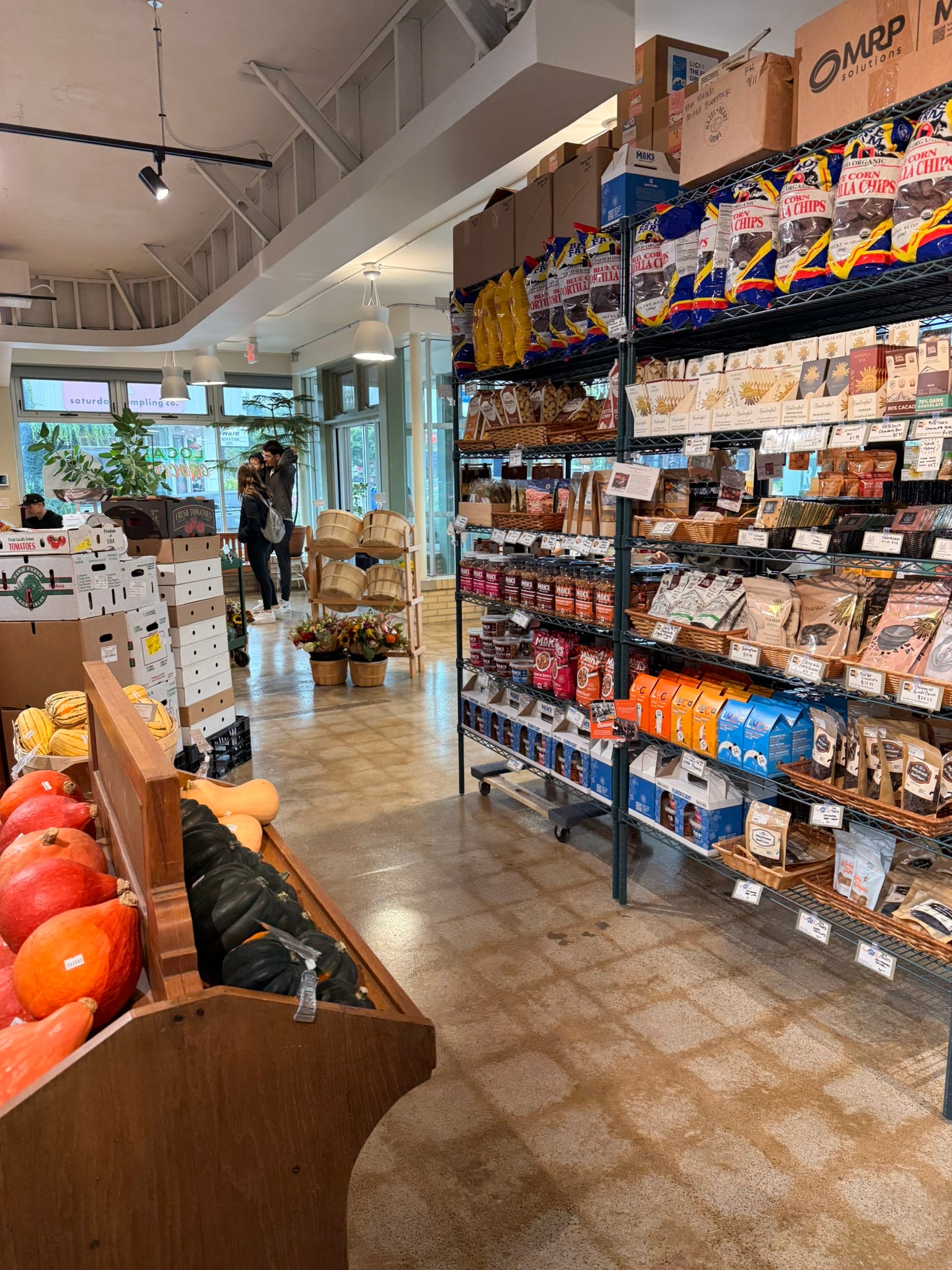 Radish Farm Stop specialty grocery aisle with shelving and produce bins