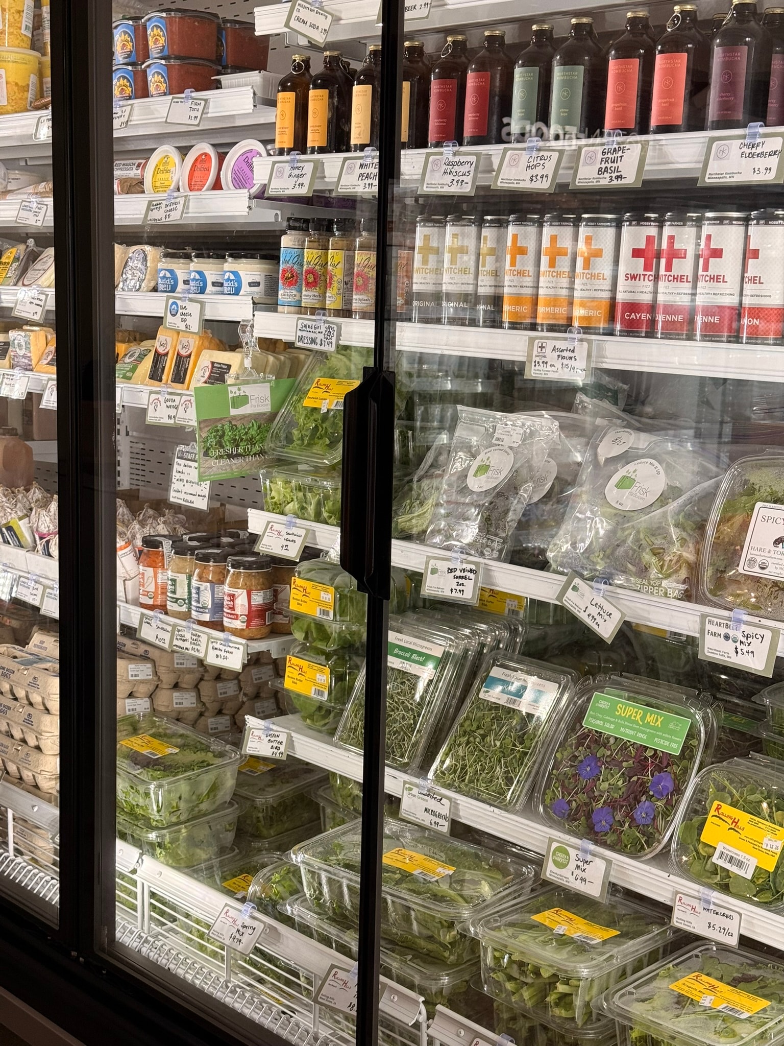 Radish Farm Stop refrigerated display case with local produce, beverages, and specialty items