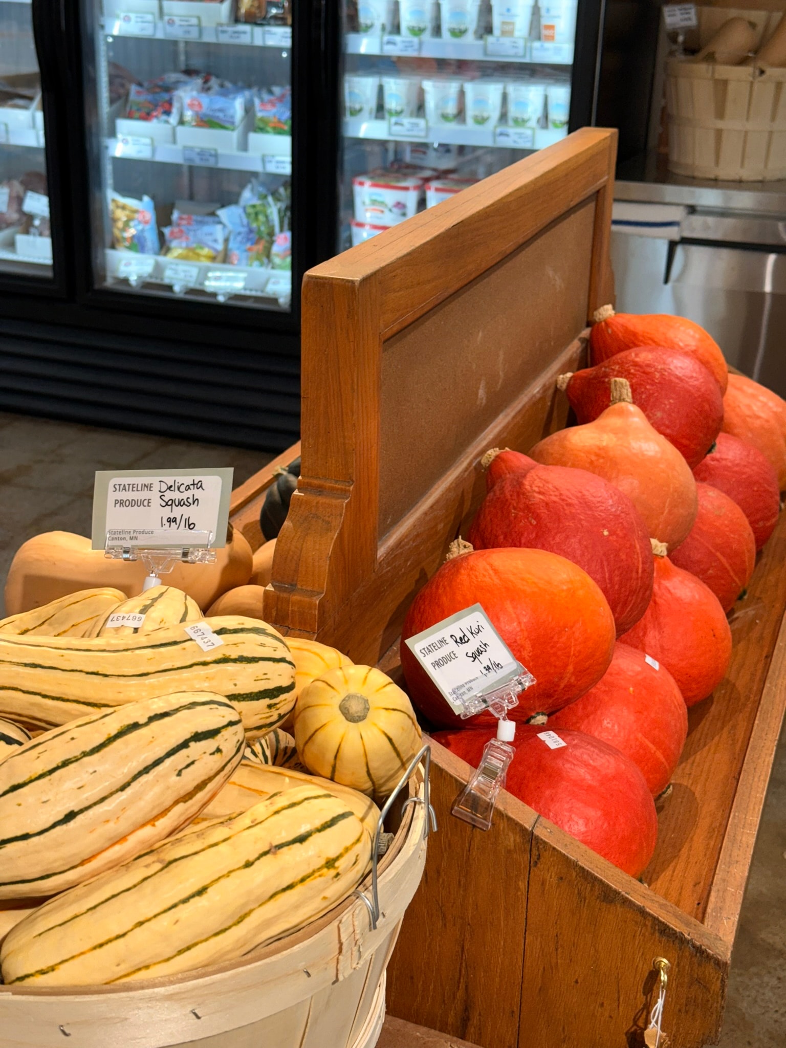Radish Farm Stop wooden produce bin with delicata and red kuri squash