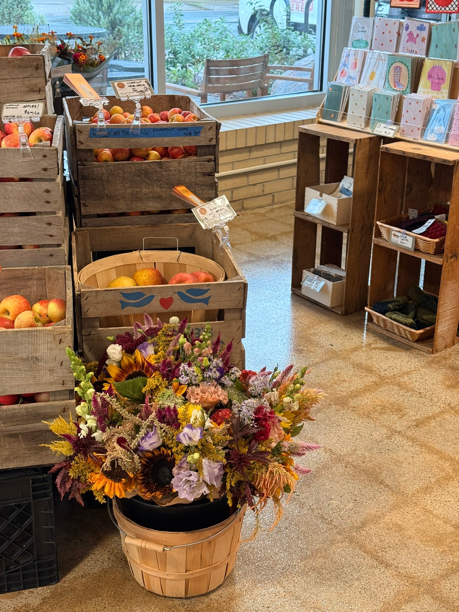 Radish Farm Stop apple crates and seasonal flower bouquet display near storefront windows