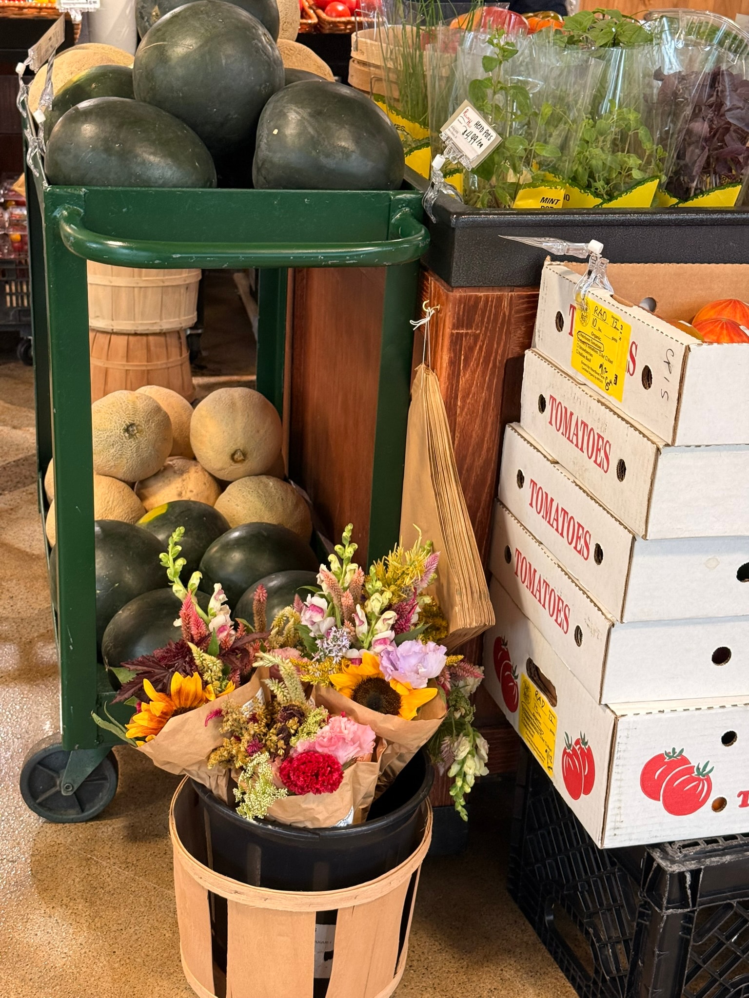 Radish Farm Stop green market cart with melons and wrapped flower bouquets